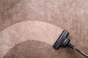 Vacuuming carpet with vacuum cleaner. Housework.